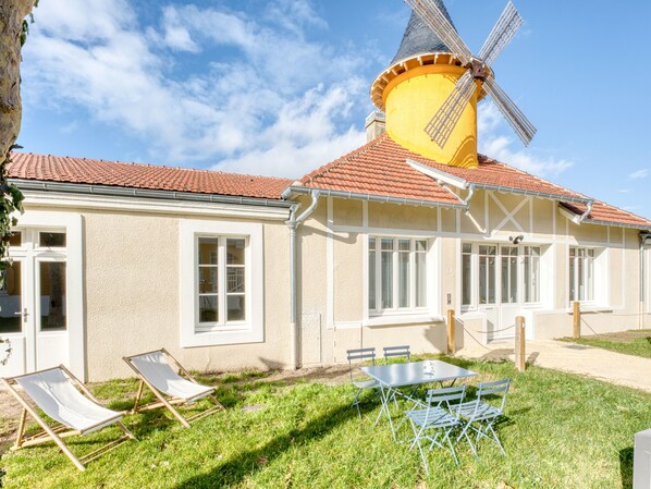 Traditional building with a charming windmill, symmetrical facade, and a cozy patio area.