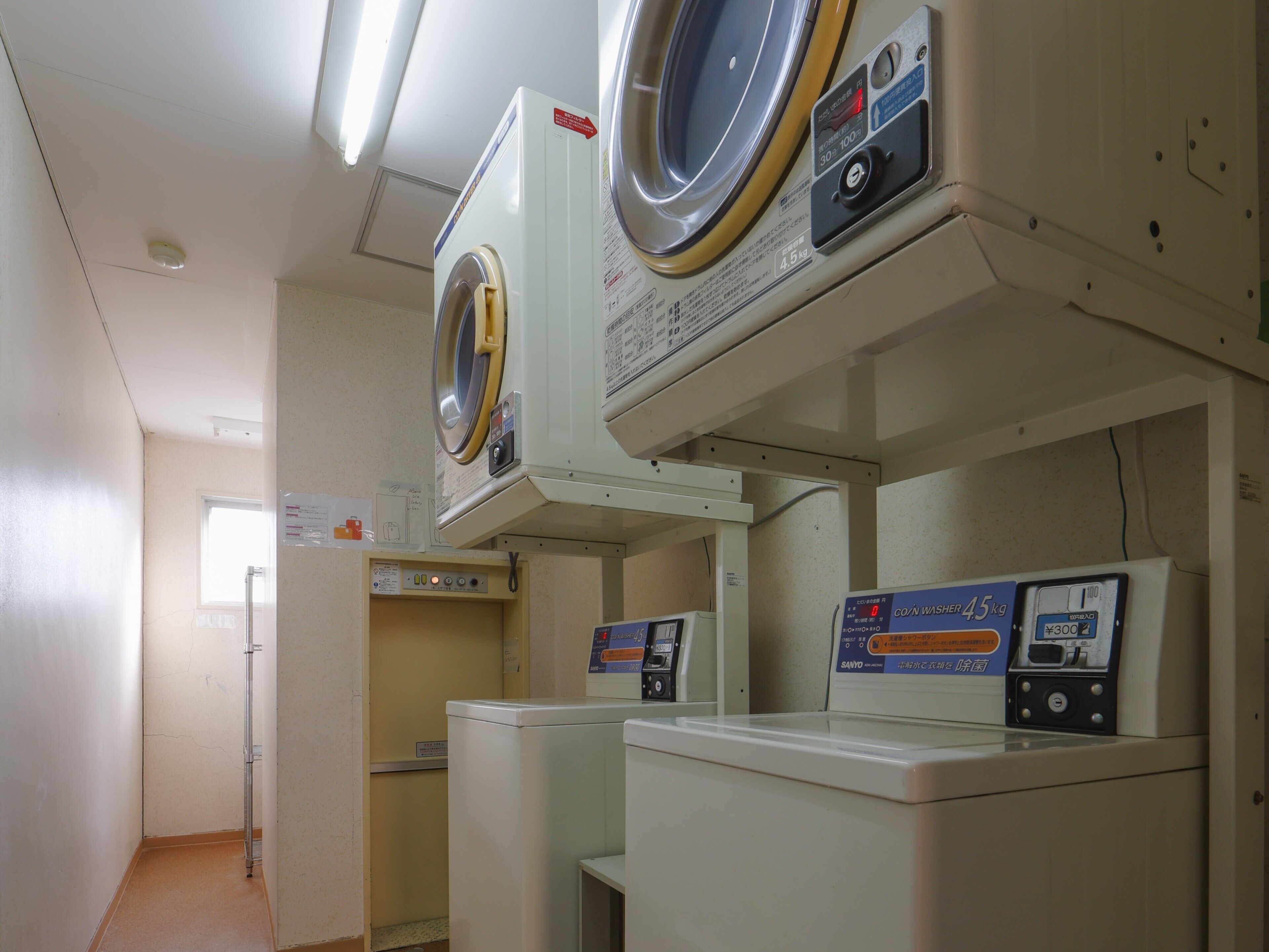 A laundry room with two washing machines and a dryer.