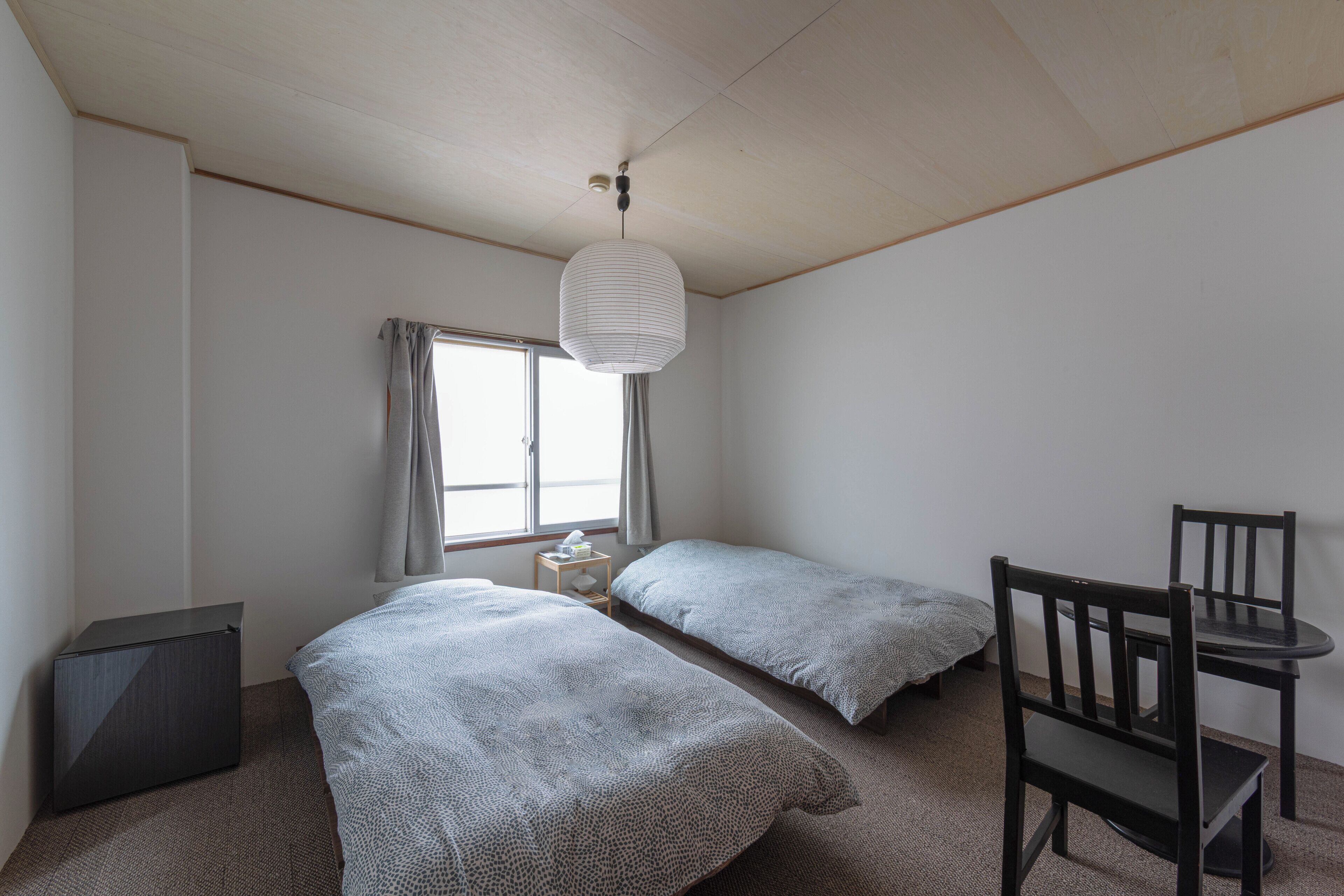 Un dormitorio con dos camas, un escritorio y una silla.