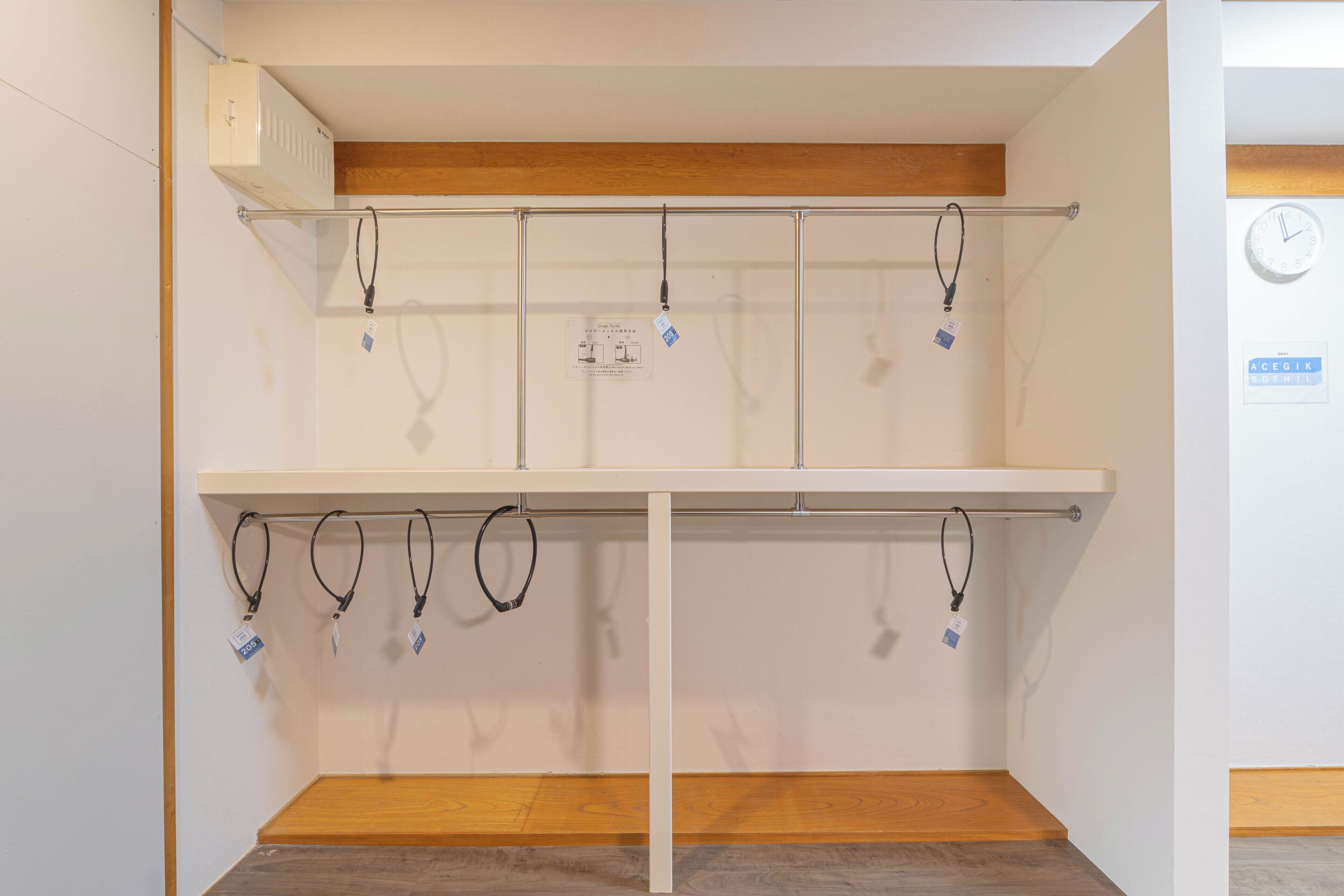 A room with a white wall, a wooden floor, a white shelf, and a white ceiling.
