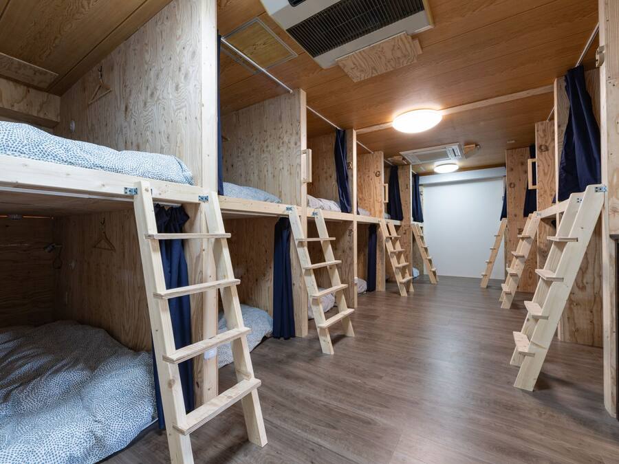 Un dormitorio con literas, escaleras de madera y un ventilador de techo.