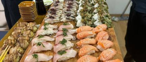 A sushi bar with various types of sushi and other dishes.