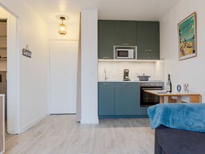 Een koelkast, een microgolfoven, een oven, kookgerei, borden en bestek