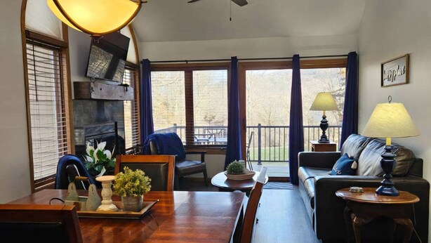 Ein geräumiges Wohnzimmer mit Essbereich, großen Fenstern und Deckenventilator.