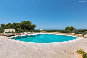 A swimming pool with lounge chairs and a view of the landscape.