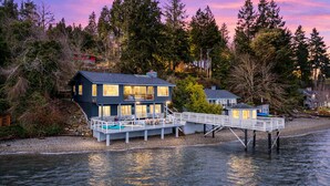 A waterfront property with a main house, a secondary structure, and a dock extending into the water.