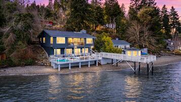 Une propriété située au bord de l’eau, comprenant une maison principale, une dépendance et un quai s’avançant dans l’eau.