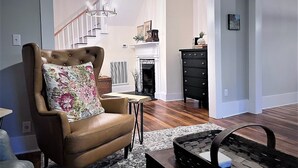 A living room with a brown leather chair, a small table, and a black dresser.