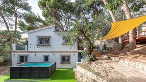 A two-story house with a swimming pool, stone retaining wall, and a yellow canopy. - AXARQUÍA - Wonderful country house with above ground pool and Free WiFi (Málaga)