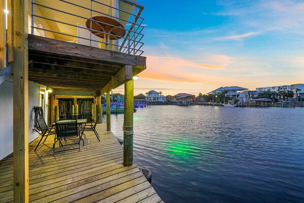 A wooden deck with outdoor seating and a view of the water.