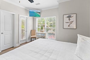 A bedroom with a bed, a TV mounted on the wall, a window with blinds, and a framed botanical print. - 🌊Walk to Beach-Great Location-4BR Pet Friendly Beachwaves Driftwood🌊 (Miramar Beach)