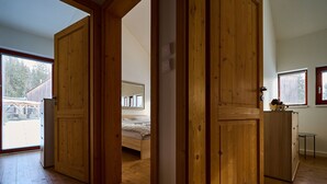 A wooden-floored room with a bed, a dresser, and a small table.
