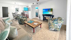 A living room with a sofa, armchairs, a coffee table, and a TV. - Sundial 1C -- Beachfront Complex. Beautiful condo just steps to the beach! (Gulf Shores)
