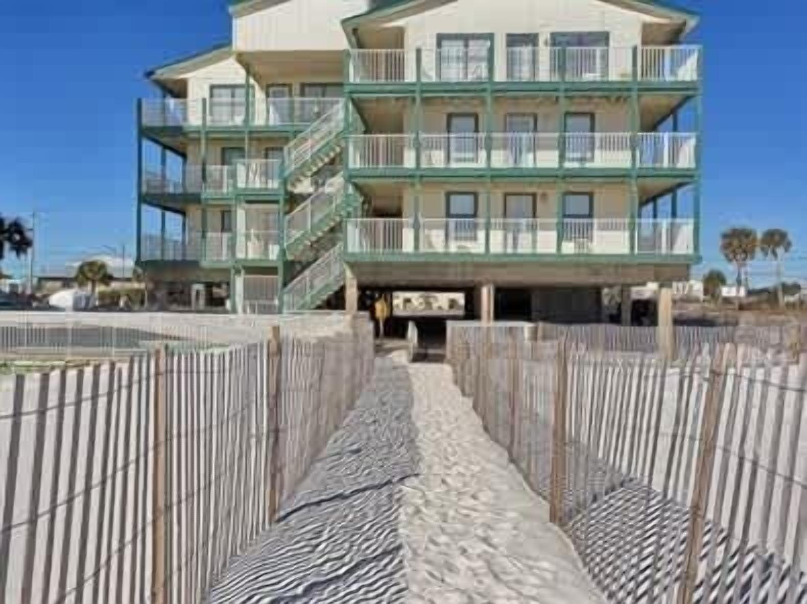 Un hôtel à plusieurs étages, doté de balcons et offrant une vue sur la plage.