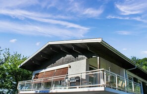 A modern house with a flat roof, a balcony with glass railings, and a barbecue grill. - 7 bedroom stunning home in Bluffy (Bluffy)
