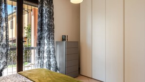 A bedroom with a bed, a wardrobe, a dresser, and a window with curtains. - GuestHost - Arezzo Equestrian Centre-Apt W/ Private Parking! (Arezzo)