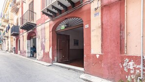 A building with a red facade, a visible door, and a number '257' on the wall. - GuestHost - Palazzo dei Normanni & Ballarò Roomy Modern Apt x9 (Palermo)