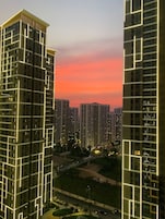 Um edifício alto com design moderno, caracterizado por um padrão de janelas em grade e linhas iluminadas.