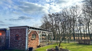 Un bâtiment en briques avec une petite fenêtre et un espace extérieur abrité.