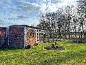 Un bâtiment en briques avec une petite fenêtre et un espace extérieur abrité.