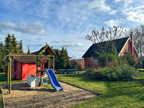 Een speeltuin met een glijbaan en een klein beschutting.