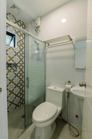 Ein modernes Badezimmer mit Duschkabine aus Glas, Toilette und Waschbecken.