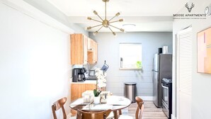 Una cocina moderna con armarios de madera, una mesa de comedor con sillas y una isla central.