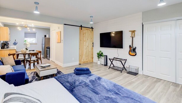 Una sala de estar moderna con un sofá, una mesa de centro y un televisor montado en la pared.