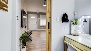 Habitación de hotel moderna con tocador, espejo y planta en maceta.