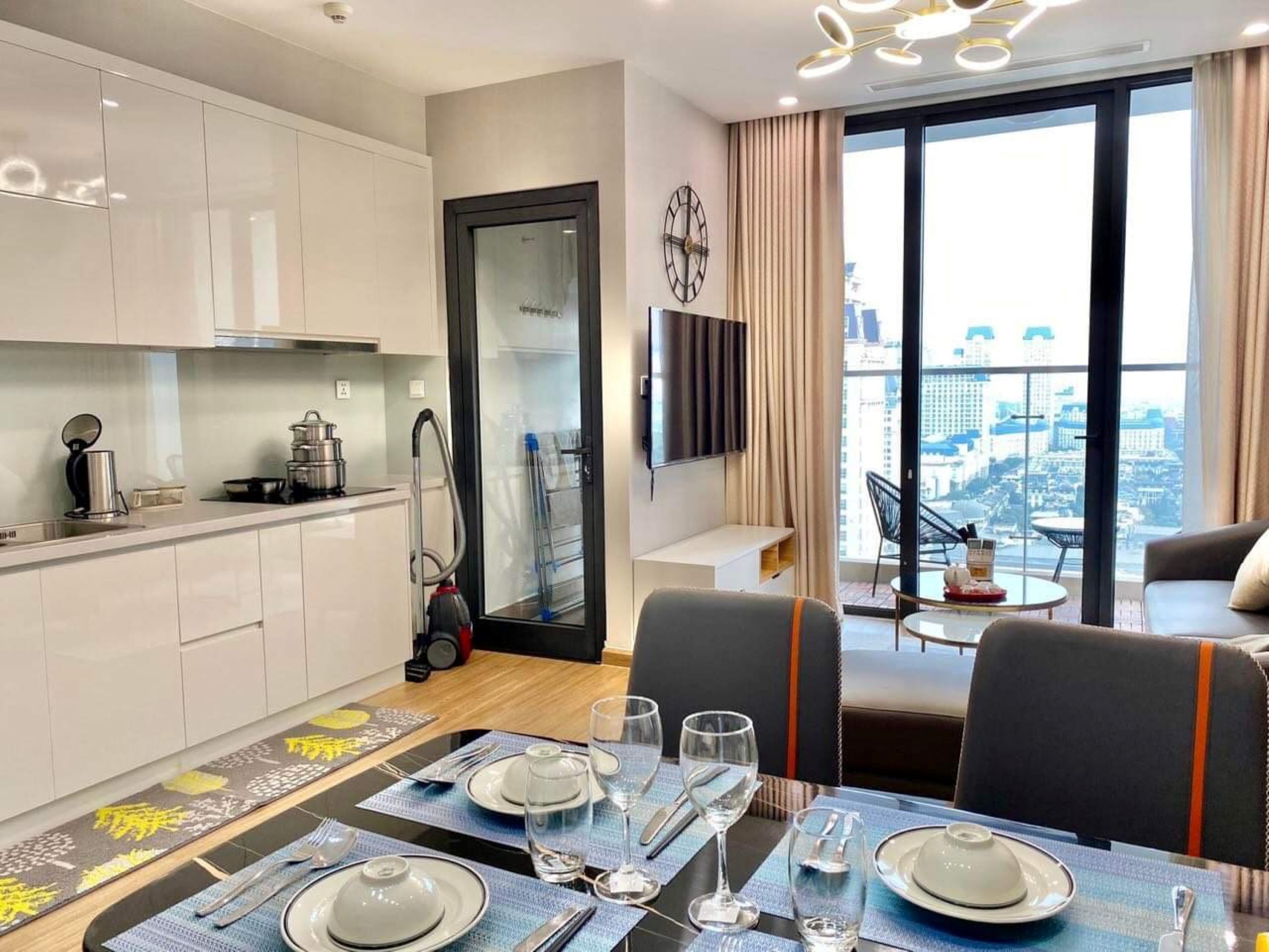 Un appartement moderne comprenant une cuisine, un coin repas et un salon avec vue sur la ville.