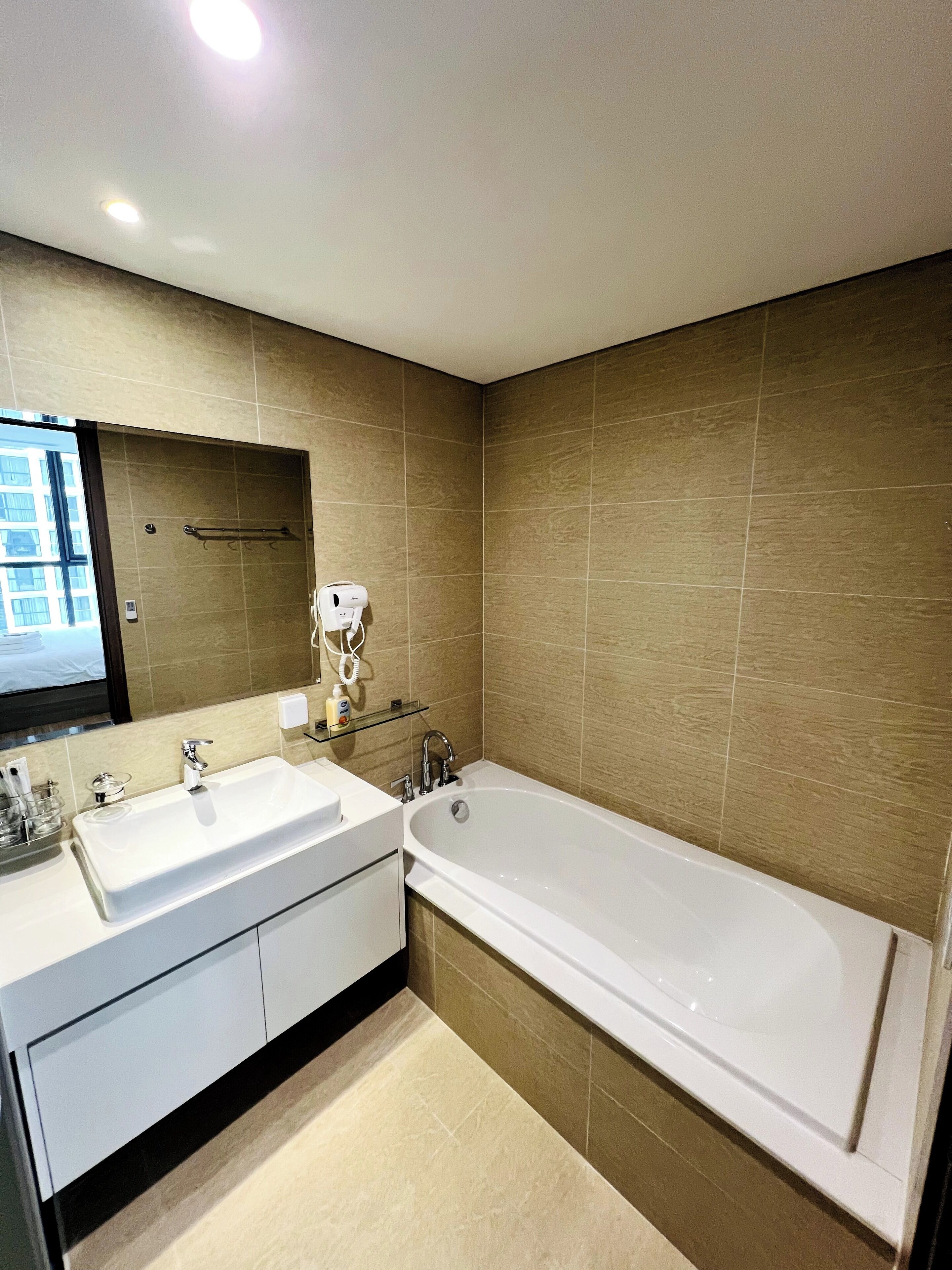Une salle de bain moderne avec une grande baignoire, deux lavabos et un miroir au-dessus des lavabos.