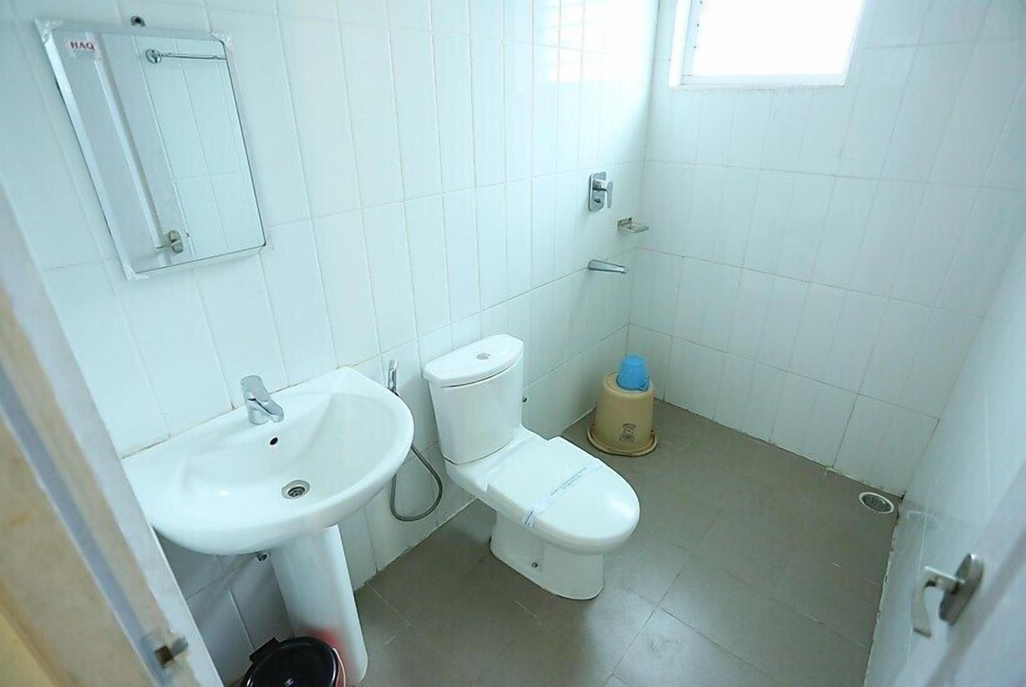 A small, clean bathroom with a sink, toilet, and a mirror.
