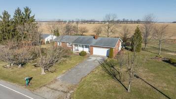 A single-story house with a garage, a driveway, and a lawn.