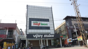 Een hotel genaamd 'Hotel Mango Leaves' met een bord voor 'Vijay Sales' boven de ingang.