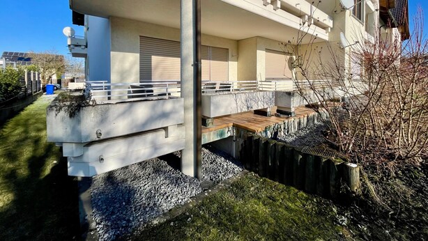 Un bâtiment moderne à deux étages, doté de balcons, d’un espace extérieur aménagé et couvert, et d’une antenne parabolique.