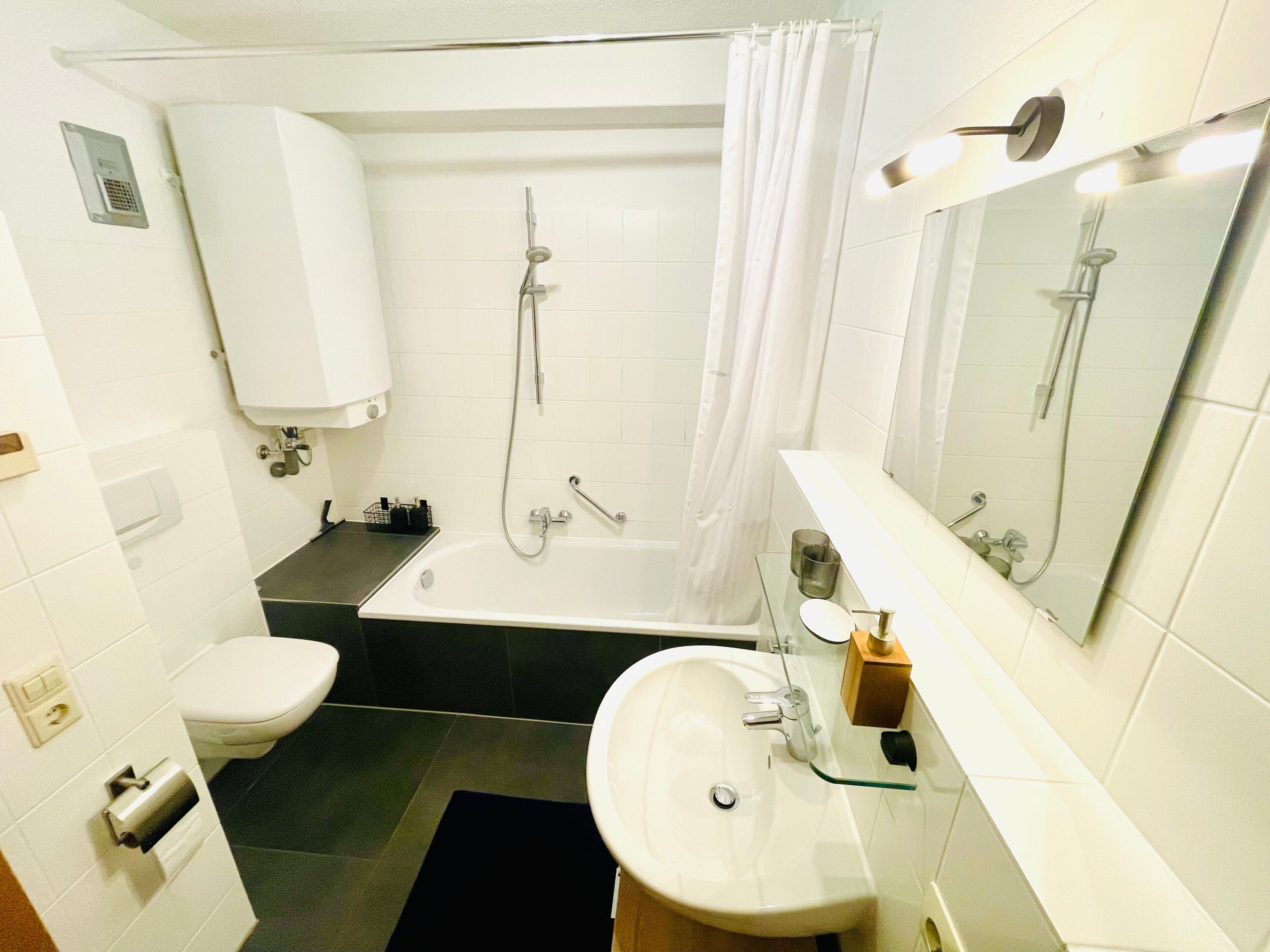 Une salle de bain comprenant des toilettes, un lavabo, une baignoire et une douche.