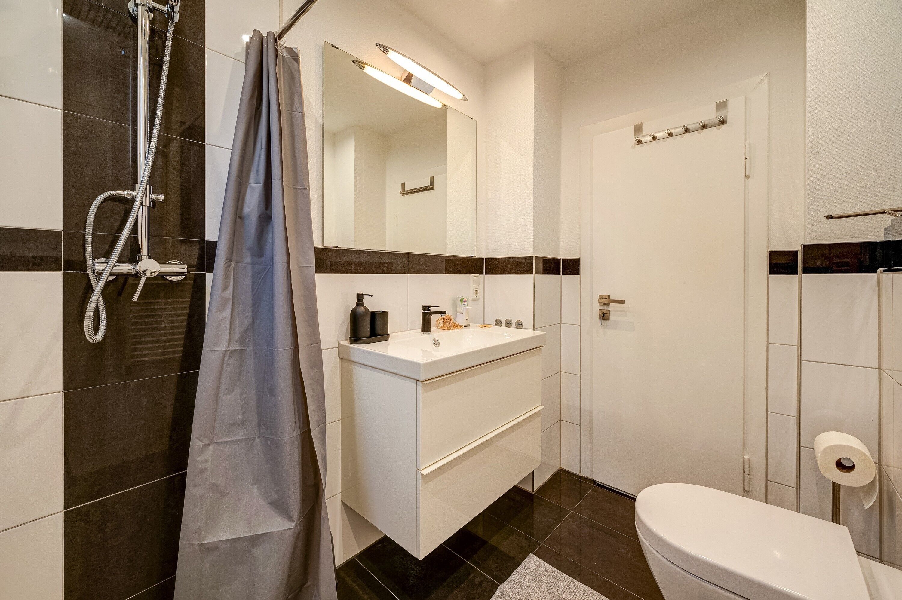 A bathroom with a shower, toilet, and sink.
