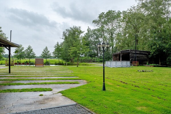 Un parc doté d’un chemin pavé, d’une structure en bois et d’un lampadaire.
