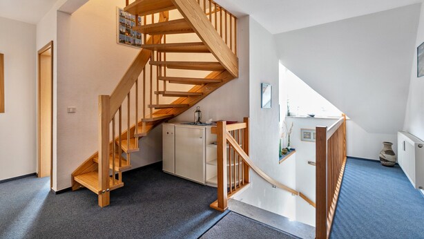 Un escalier en bois mène à une chambre située en mezzanine, d’où l’on peut admirer le ciel.