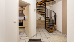 A modern kitchen with a built-in oven and a dining area with a wooden table. - Apartment 'Ferienwohnung Rinke' with Mountain View and Balcony (Schmallenberg)