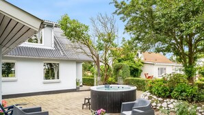 A patio area with outdoor furniture, a hot tub, and a garden with various plants and a hedge. - "Elara" - 300m from the sea by Interhome (Thyholm)