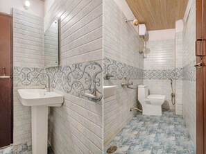 A bathroom with a sink, toilet, and shower. The walls have a patterned tile design. - iROOMZ Hotel Royal Hill Park (Hyderabad)