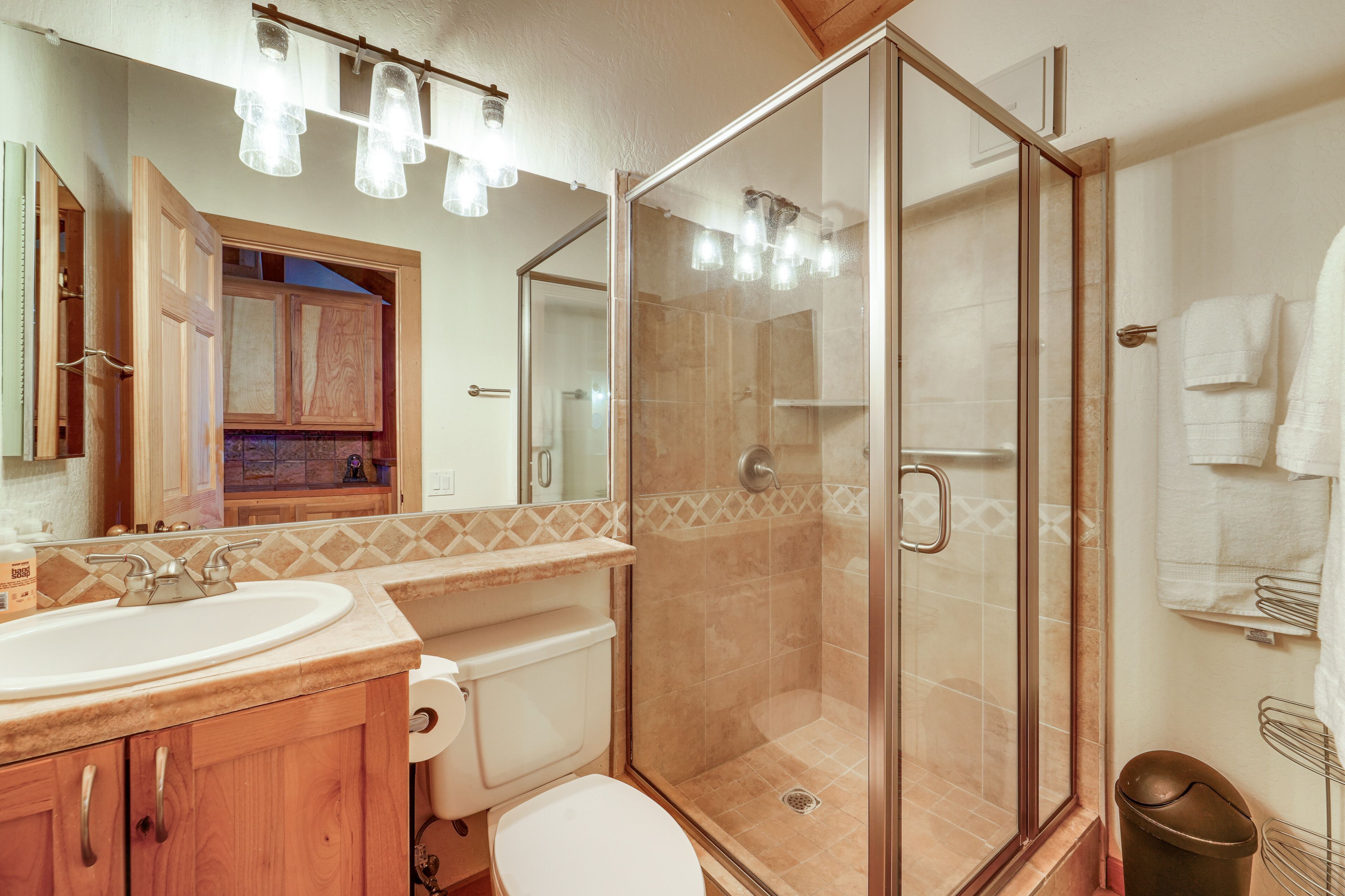 Un baño con ducha de vidrio, lavabo e inodoro.
