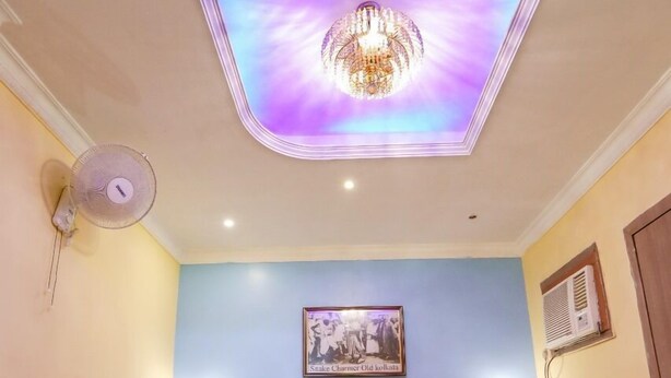 A hotel room with a bed, a ceiling light, a wall-mounted picture, and a bedside table. - Hotel Orbit Digha (Kanthi)