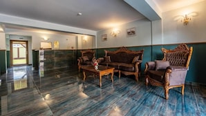 A lobby with a polished marble floor, a reception desk, and a seating area with ornate wooden furniture. - Hotel PrincesSophie (Sighisoara)