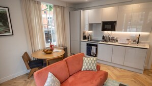 Een knus verblijf met een kitchenette, een eethoek en een bank.