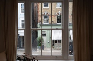 Ein Fenster mit Blick auf ein Gebäude mit grüner Fassade und einem weißen Vordach.