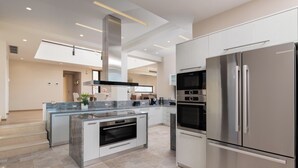 A modern kitchen with a central island, built-in oven, stainless steel appliances, and a large window. - Elias Rest Villa with private pool (Pastida)