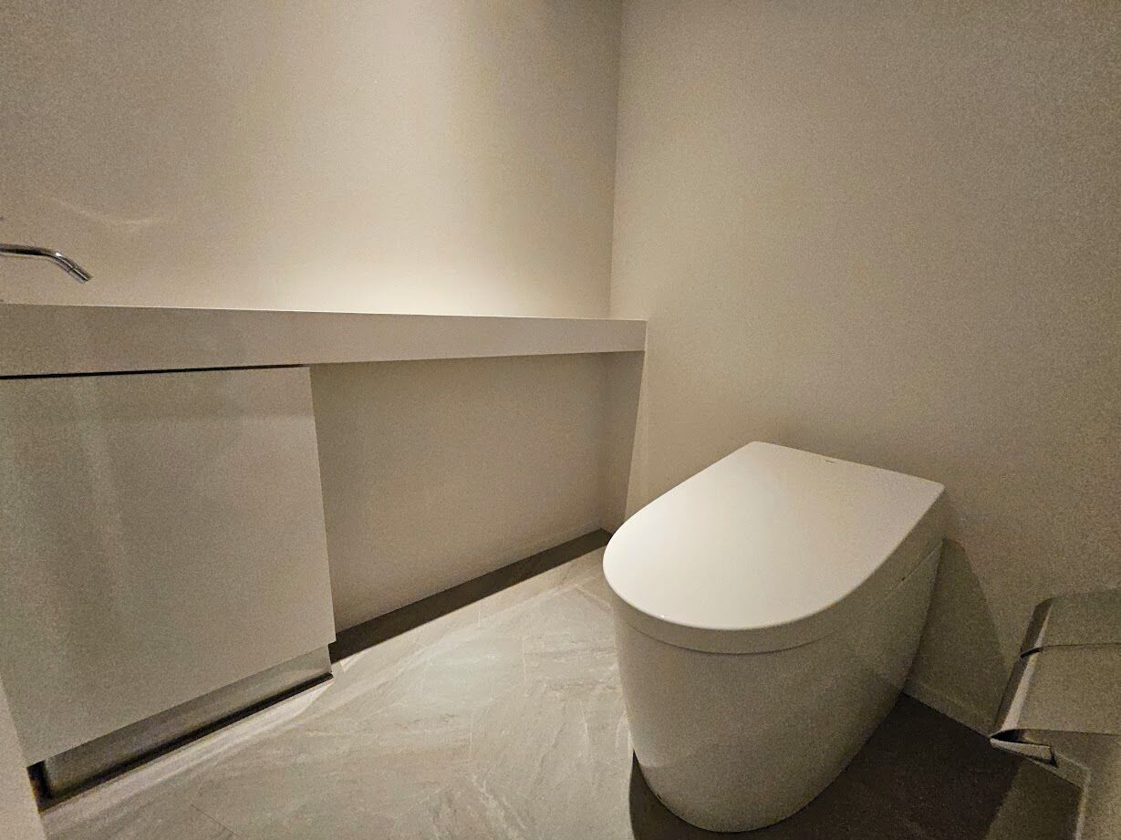 Une salle de bain moderne équipée de toilettes, d’un meuble-lavabo et d’un espace douche.