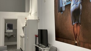 A modern living room with a flat-screen TV, a ceiling fan, and a large painting of a woman by a window. - Golondrinas de Malaga (Málaga)